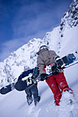Zwei junge Personen tragen Snowboards, Kühtai, Tirol, Österreich