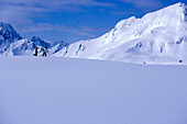 Two skier walking through snow, mountains in the background, Kuehtai, Tyrol, Austria