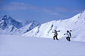 Zwei Skifahrer laufen auf schneebedecktem Berg, Kühtai, Tirol, Österreich