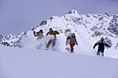 Vier Person laufen schneebedeckten Hang hinunter, Kühtai, Tirol, Österreich