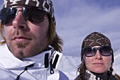 Junges Paar steht an der Skipiste, beide tragen Sonnenbrillen, Kühtai, Tirol, Österreich