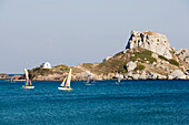 View over bay of Kefalos with catamarans and surfer to Kastri island with capel St. Nicholas, Kefalos, Kos, Greece