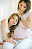 Girl listening to pregnant mothers stomach, close up