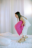 Girl playing with pillow