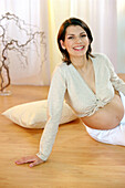 Schwangere Frau sitzt auf dem Boden, Portrait