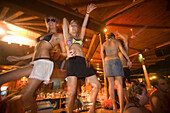 Young girls dancing a table during the full moon party, Tropicana Club, Paradise Beach, Mykonos, Greece
