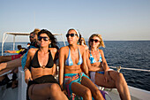 Three women using the boat transport to the Paradise and Super Paradise Beach, Psarou, Mykonos, Greece