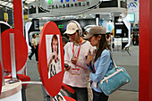 CeBIT Asia, Shanghai 2005,young couple, Computermesse, fair, Ableger Hannover-Messe, Kooperation, Hightech, CeBIT Asia 2005, chinesische Messebesucher, Rot, red