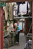 old town, Lao Xi Men,Frau, Waschplatz in Gasse, Wohngasse, Woman washing at a communal water supply, domestic household chores of a traditional house, chinese house fronts onto the street, laundry, beengtes Wohnen, close living