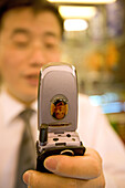 mobile phone,Mobilfunk, Handy, Telefon, chinesisch, salesman with mobile phone, portrait of Mao, Konterfei von Mao, Maoist, Verkäufer mit Handy, Mao Portrait