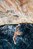 Kletterer springt vom Bouldern ab ins Meer, Mallorca, Spanien