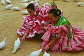 Girls feeding doves,Feria de Abril,Sevilla,Andalusia,Spain