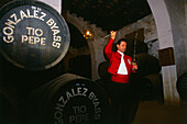 Mann in Tracht füllt Sherry in ein Glas, Bodegas Gonzales Byass, Jerez de la Frontera, Provinz Cadiz, Andalusien, Spanien, Europa