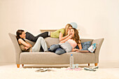 Three teenage girls (14-16) sitting on sofa and talking