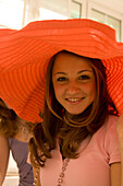 Teenagerin (14-16) trägt großen Hut, lächelt