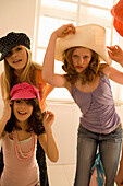 Teenage girls (14-16) posing, wearing hats