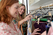 Junge Frauen schauen Kleider im Laden an