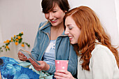 Two young women looking at photographs