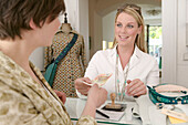 Young woman paying cashier in shop