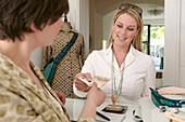 Young woman paying cashier in shop