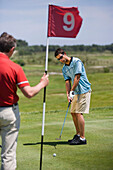 Male golfer preparing to hit ball, Apulia, Italy