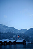 A hotel and snow covered huts at the lake shore, Königssee, Berchtesgardener Land, Bavaria, Germany