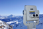 Coin-operated binoculars in front of snow covered landscape, Passo Pordoi, Dolomites, Italy, Europe