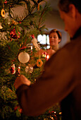 Mid adult couple decorating christmas tree
