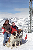 Tourist couple with Saint Bernard dogs, Zermatt, Switzerland