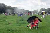People with umbrellas at Isar meadows, Solar eclipse 1999, Munich, Bavaria, Germany, Europe