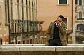 Man with mobile phone on Bridge in Venice, Italy