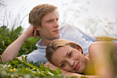 Couple lying in grass, sideview