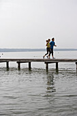 Man and woman running on jetty