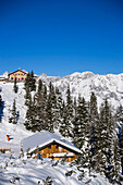 View to snowy hill with Hochwurzenalm and Hochwurzenhütte (1850 m), summit of the Dachsteinregion at horizon, Hochwurzen, Schladming, Ski Amade, Styria, Austria