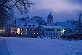 Snow covered houses on the island Fraueninsel in the evening, lake Chiemsee, Bavaria, Germany
