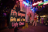 Three Go-go girls in front of a nightclub, one woman holding a sign, Patpong, red light and entertainment district, Bang Rak district, Bangkok, Thailand