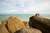 Paar sonnt sich auf einem Felsen, Lamai Strand, Hat Lamai, Ao Lamai, Ko Samui, Thailand