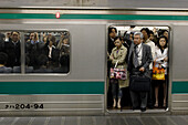 Menschen stehen in einer überfüllten U-Bahn, Tokio, Japan