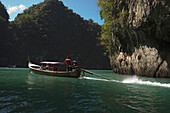 People driving a boat through Ko Hong Island lagoon, Krabi, Thailand