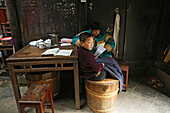 Two boys doing homework in a residential house at the village Hongcun, Huangshan, China, Asia