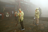 Pilgrims, tourists in rain capes at the entrance to Bixia Si temple, Mount Tai, Tai Shan, Shandong province, World Heritage, UNESCO, China