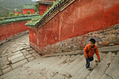 Kind auf den Treppen zum Tempel, Palast der Purpurwolke, Zi Xiao Gong, auf halbem Weg zum Gipfel des Wudang Shan, rote Mauern, daoistischer Berg in der Provinz Hubei, Geburtsort des Taichi, China, Asien, UNESCO Weltkulturerbe