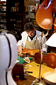 Man making a violin, Antique Violin repair shop, Old Town, Prague, Czech Republic