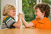 Two boys arm wrestling, children's birthday party