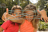 Two Girls playing cat's cradle, children's birthday party