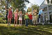 Children holding hands and jumping, children's birthday party