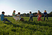 Kinder spielen Tauziehen, Kindergeburtstag