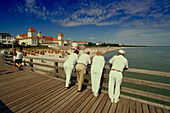 Urlauber stehen auf der Seebrücke und blicken auf Strand und Kurhaus, Binz, Rügen, Mecklenburg-Vorpommern, Deutschland