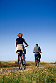 Couple riding bike, Prerow, Fischland-Darss, Zingst, Mecklenburg-Western Pomerania, Germany