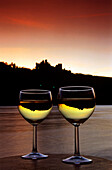 Mirroring of Schonburg Castle in two glasse of white wine, Oberwesel, River Rhine, Rhineland-Palatinate, Germany